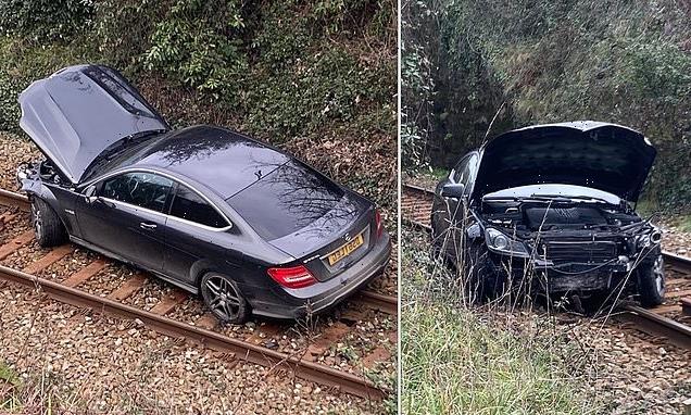 Parking mad! Police hunt for driver of Mercedes dumped on train tracks